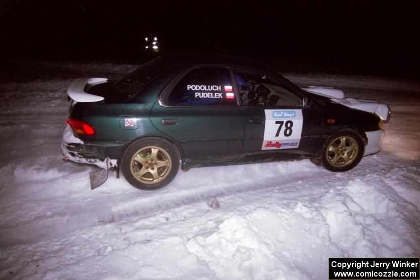 The Mark Podoluch / Kazimierz Pudelek Subaru Impreza drifts through the first corner of the evening running of the ranch stage.