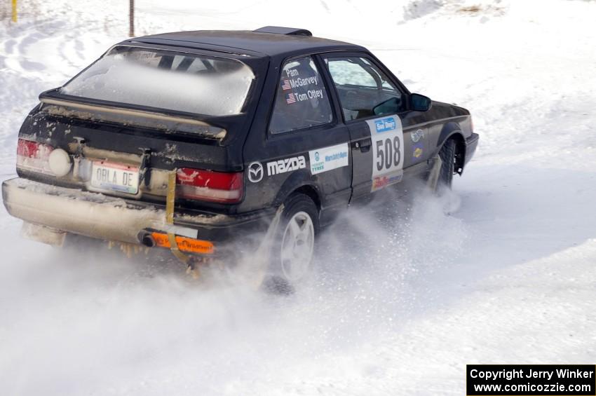 Tom Ottey / Pam McGarvey Mazda 323GTX at a 90-left on the first stage of day two.