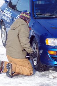 Carrie Carlson tightens the lugs on the Mark Utecht / Brent Carlson / David Steen, Sr. / Matt Shaefer Subaru Impreza 2.5RS