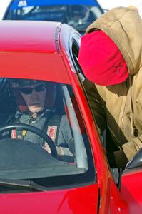 Brent Carlson straps into the driver's seat of the #84 Subaru Impreza