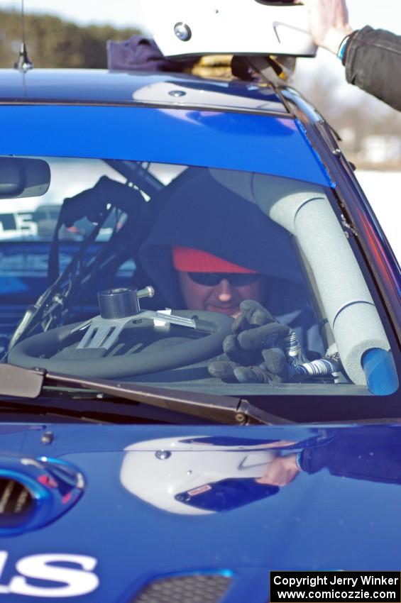 Mark Utecht straps into the driver's seat of the #83 Subaru Impreza 2.5RS