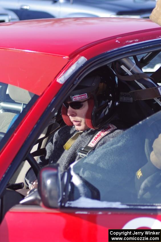 Brent Carlson straps into the driver's seat of the #84 Subaru Impreza