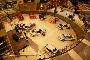 A view from the upper floor of the Mall of America of rally cars on display (1).