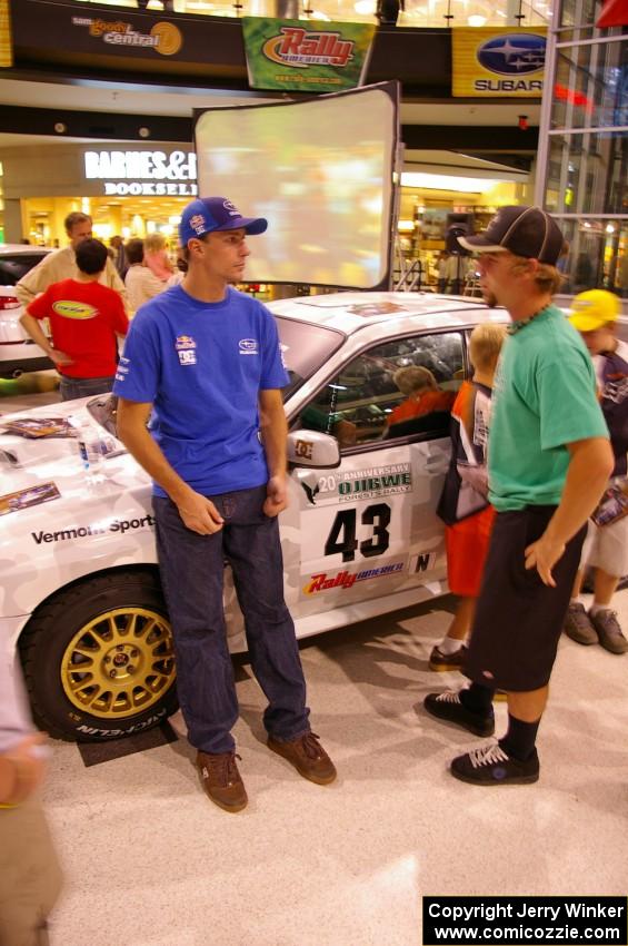 Travis Pastrana talks to a fan in front of the Ken Block / Alex Gelsomino Subaru WRX STi.