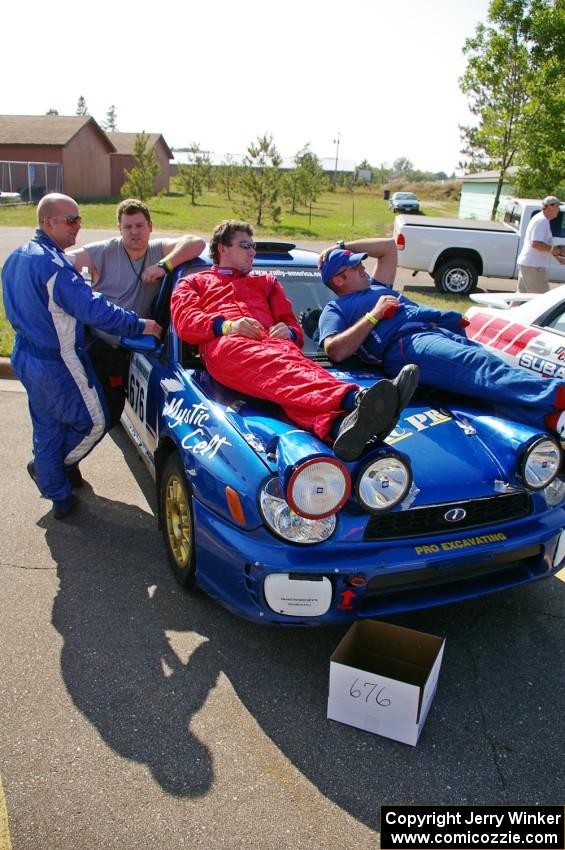 Mark McElduff and Damien Irwin relax on their Subaru WRX STi while Fintan McCarthy and Noel Gallagher converse.