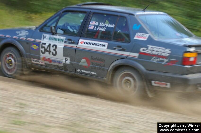 Mike Merbach / Jeff Feldt VW Jetta at speed through a fast uphill left on SS10, Chad's Yump.