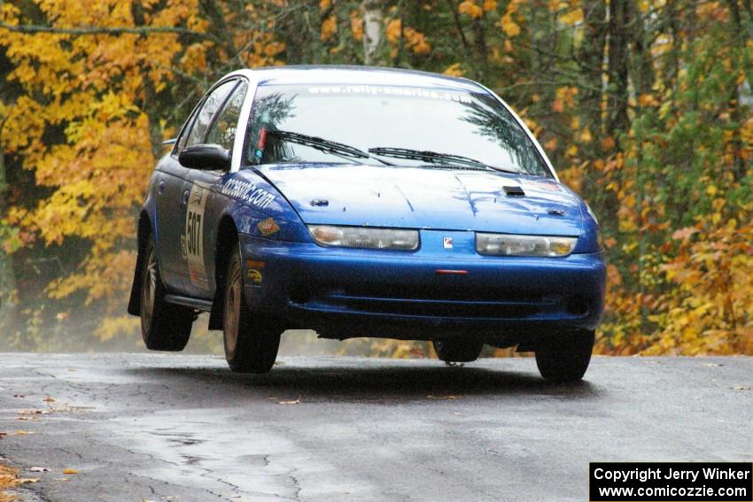 Micah Witala / Jason Takkunen Saturn SL2 get minor air at the midpoint jump on Brockway, SS10.