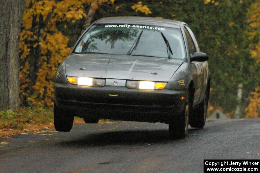 Dan Adamson / Chris Gordon Saturn SL2 gets the right side light at the midpoint jump on Brockway, SS10.