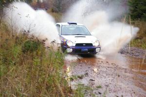 Tanner Foust / Scott Crouch Subaru WRX hits the final big puddle at the end of Gratiot Lake 2, SS14, at speed.