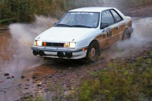 Greg Woodside / Tom Woodside Dodge Shadow Turbo hits the final big puddle at the end of Gratiot Lake 2, SS14, at speed.