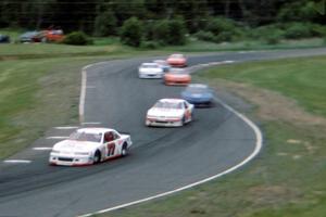 Dave Watson's Chevy Lumina and Butch Miller's Ford Thunderbird lead a group of cars through turns 7/8