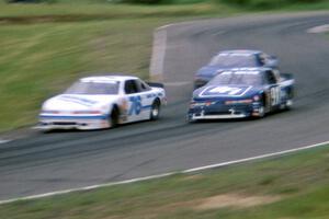 John Cadman's Olds Cutlass Supreme and Tom Harrington's Olds Cutlass Supreme go through turn 8