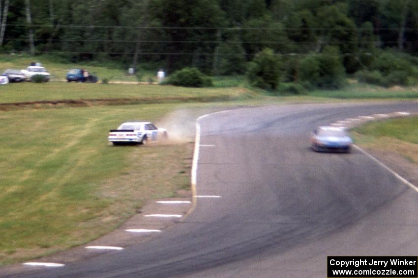 Scott Hansen's Chevy Lumina spins at turn 7 as Bob Senneker's Ford Thunderbird goes by.