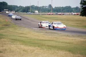 Ken Schrader's Chevy Monte Carlo and Tony Raines' Pontiac Grand Prix lead the field into 7/8.