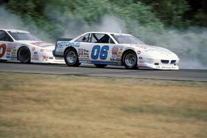 Leighton Reese's Pontiac Grand Prix keeps ahead of John Cadman's Ford Thunderbird into turn 3.