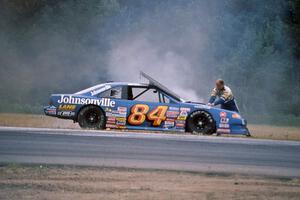 Bob Senneker throws sand onto an engine fire on his Ford Thunderbird