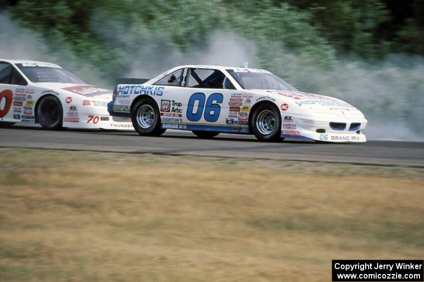 Leighton Reese's Pontiac Grand Prix keeps ahead of John Cadman's Ford Thunderbird into turn 3.