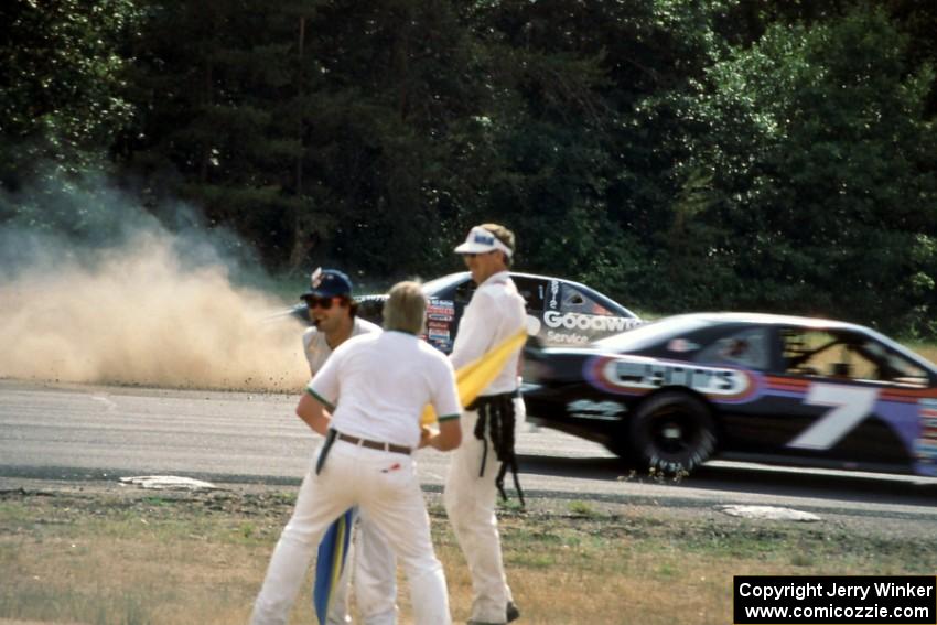 Mike Eddy's Pontiac Grand Prix spins at turn 3 as Gary St. Amant's Ford Thunderbird passes by.