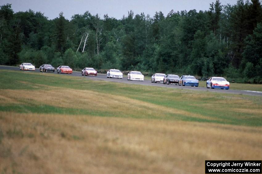 Ken Schrader's Chevy Monte Carlo leads the field into turn 3