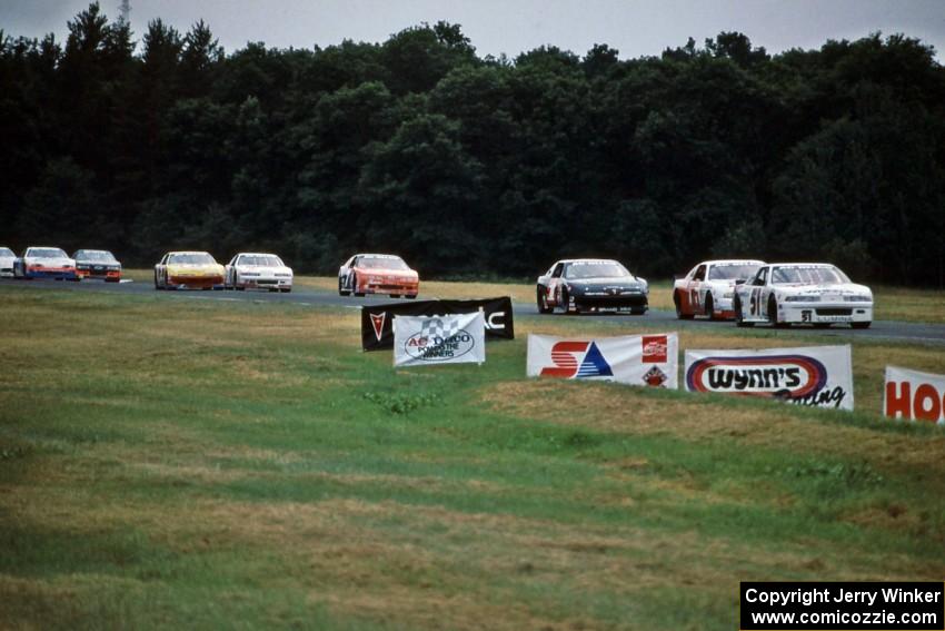 Brandon Sperling's Chevy Lumina leads John Freeman's Chevy Monte Carlo and Jay Sauter's Pontiac Grand Prix out of turn 3