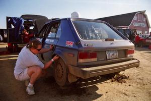 Mary Utecht checks rear-tire clearance on the Mark Utecht / Paul Schwerin Dodge Omni GLH Turbo at Park Rapids service.