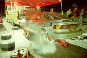 A crewman furiously works on the Bruce Newey / Matt Chester Toyota Celica Turbo at the first Kenton service.