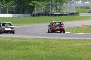 Tubby Butterman BMW 325 passes the Speedlab BMW 325e exiting the carousel