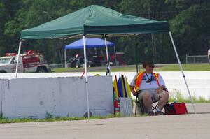 The flagger at turn 13 tries to keep cool in the shade