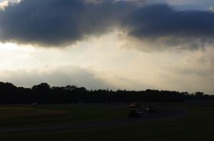 Four cars head through turn 4 into 5 about an hour before sundown.