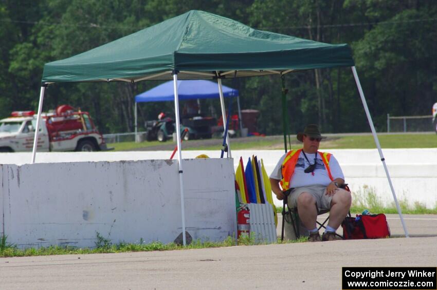 The flagger at turn 13 tries to keep cool in the shade