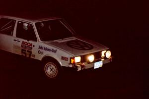 Damien Crane / John Adams-Graf head through the crossroads in their VW Rabbit at night.