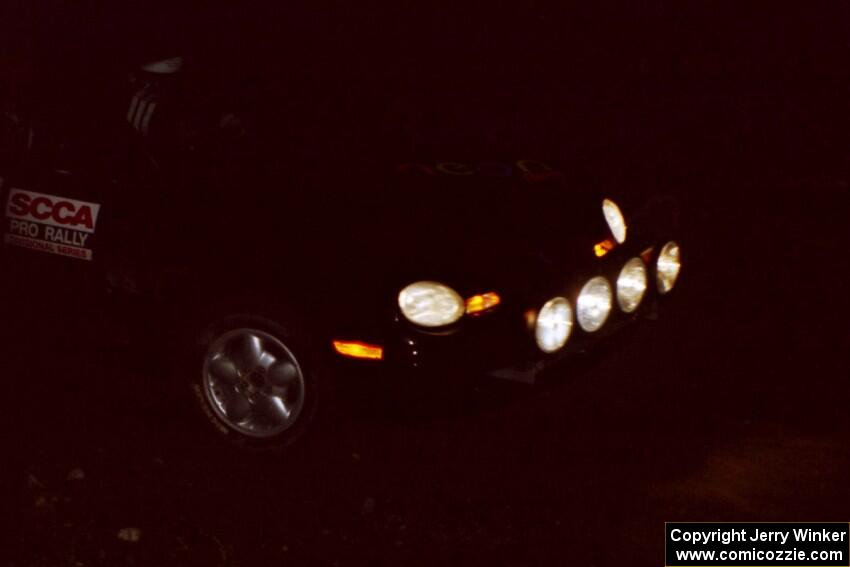 Evan Moen / Ron Moen drive their Dodge Neon through the crossroads at night.