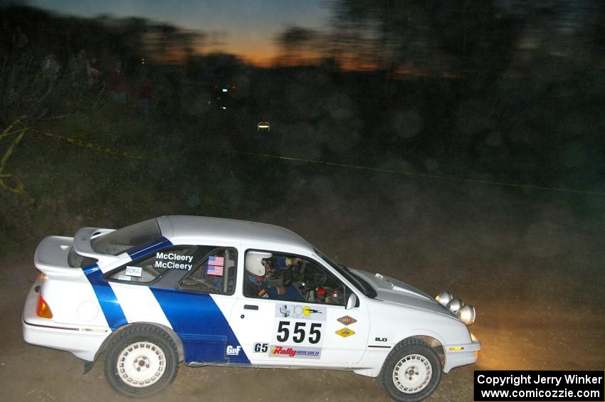 Colin McCleery / Nancy McCleery wade through the dust at a dowhill right in their Ford Sierra XR8.