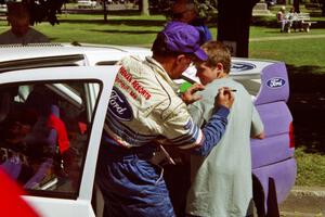 Carl Merrill signs autographs in front of the Ford Escort Cosworth RS he and Lance Smith shared