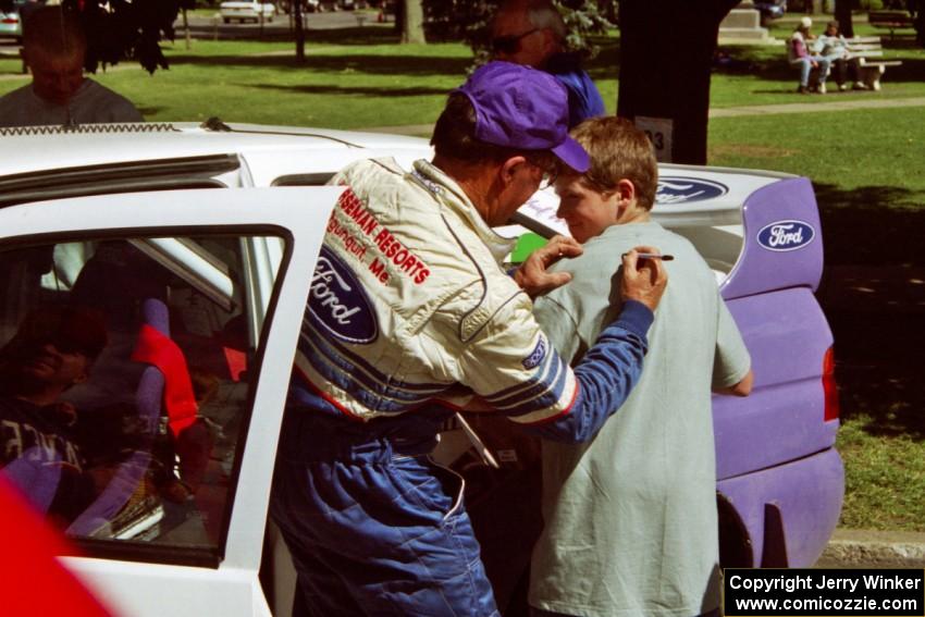 Carl Merrill signs autographs in front of the Ford Escort Cosworth RS he and Lance Smith shared