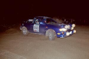 Kyle Sarasin / Stuart Sarasin drift wide and sling gravel at the SS8, Kabekona, spectator point in their Subaru Impreza.