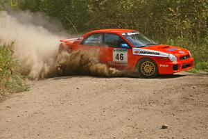 Matthew Johnson / Kim DeMotte Subaru WRX slings gravel at a 90-left on SS9.