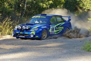 Travis Pastrana / Christian Edstrom Subaru WRX STi comes out of the woods and onto the county road on SS14.