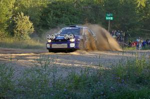 Tanner Foust / Chrissie Beavis Subaru WRX throws a wave of gravel over the car at the SS14 spectator point.