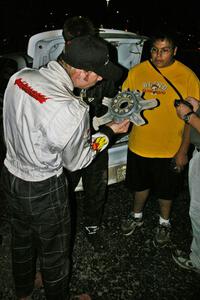 Matthew Johnson inspects the destroyed wheel of Tanner Foust as Russ Johnson looks on.