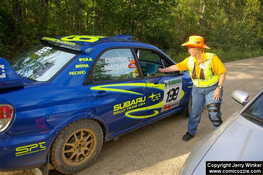 Barbara Steencken hands the timecard back to Travis Pastrana / Christian Edstrom Subaru WRX STi at the finish control of SS2.