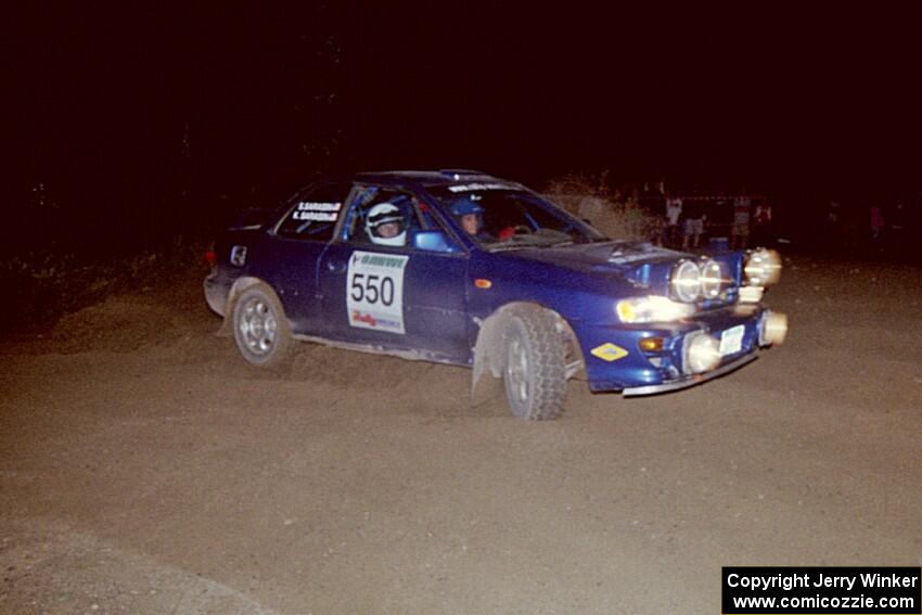 Kyle Sarasin / Stuart Sarasin drift wide and sling gravel at the SS8, Kabekona, spectator point in their Subaru Impreza.