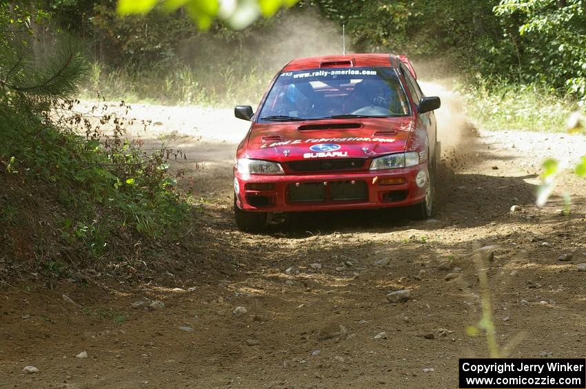 Erik Schmidt / Mike Rose drift through a right-hander on SS13 in their Subaru Impreza.