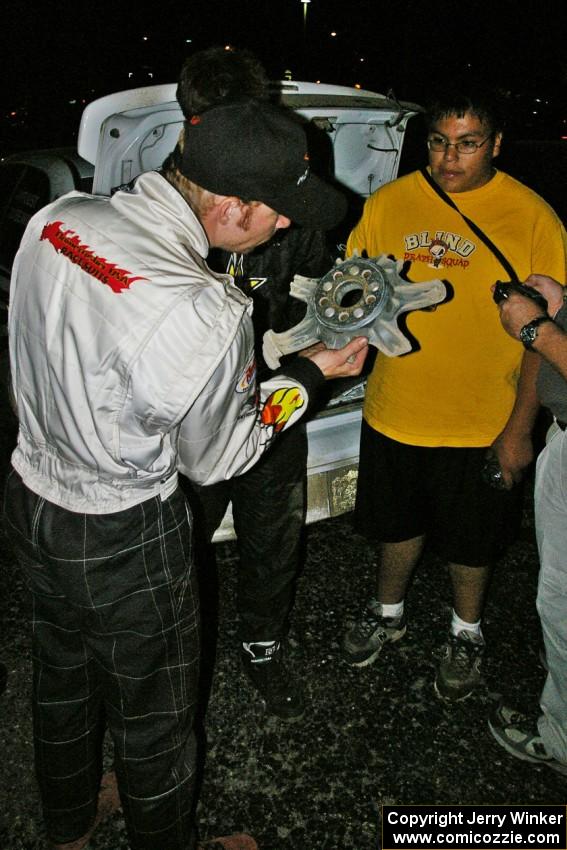 Matthew Johnson inspects the destroyed wheel of Tanner Foust as Russ Johnson looks on.