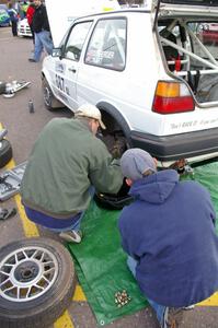 Chad Eixenberger / Jay Luikart change the left-rear brakes on their VW GTI at parc expose.