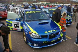 Travis Pastrana poses with a young fan at parc expose next to his Subaru WRX STi.