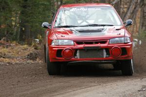 Dennis Martin / Alex Kihurani drift their Mitsubishi Lancer Evo IV around a hard left-hander near the start of SS1, Herman.