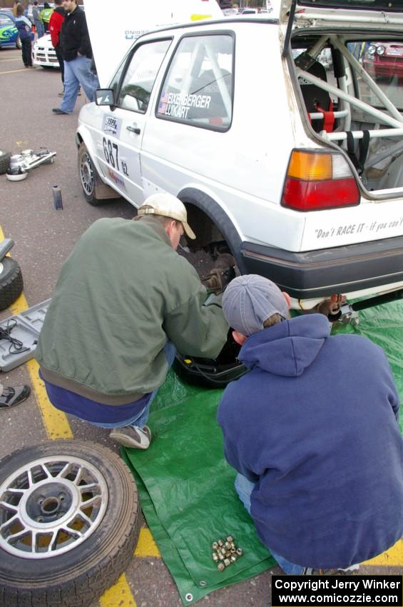 Chad Eixenberger / Jay Luikart change the left-rear brakes on their VW GTI at parc expose.