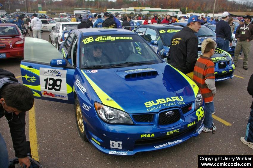 Travis Pastrana poses with a young fan at parc expose next to his Subaru WRX STi.