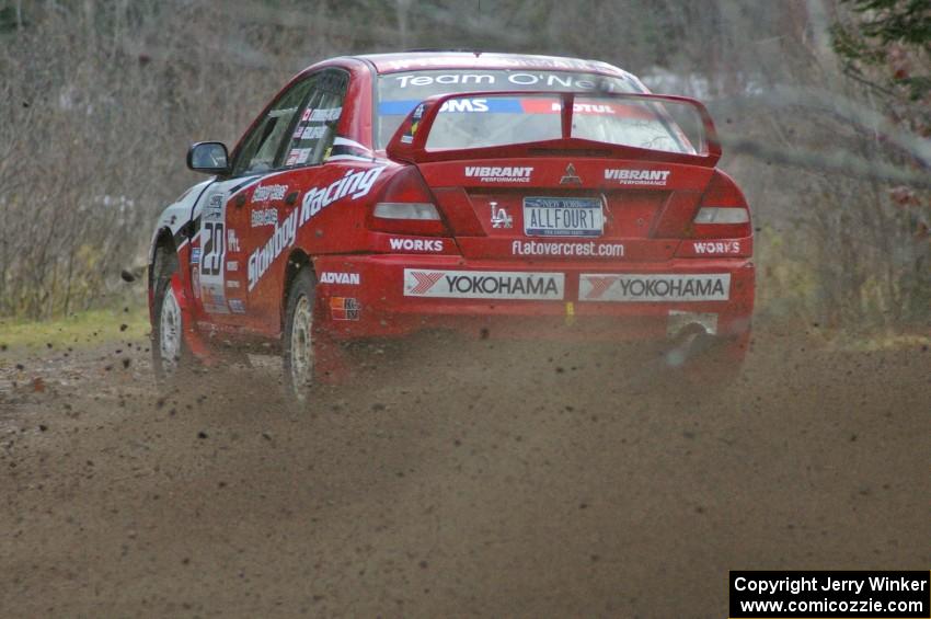 Andrew Comrie-Picard / Marc Goldfarb sling gravel at a fast left-hander on SS1 in their Mitsubishi Lancer Evo IV.
